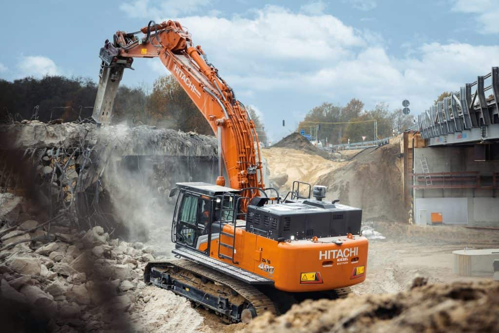 An orange excavator digging dirt in a construction site